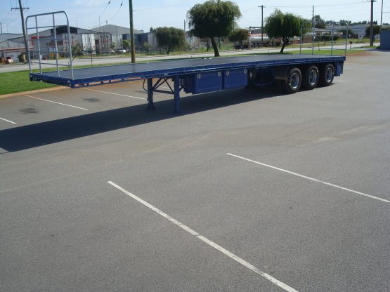 TSE Blue Flat Top Semi trailer side view in parking lot